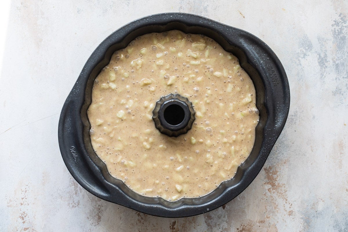 Cinnamon apple cake batter in a bundt pan.