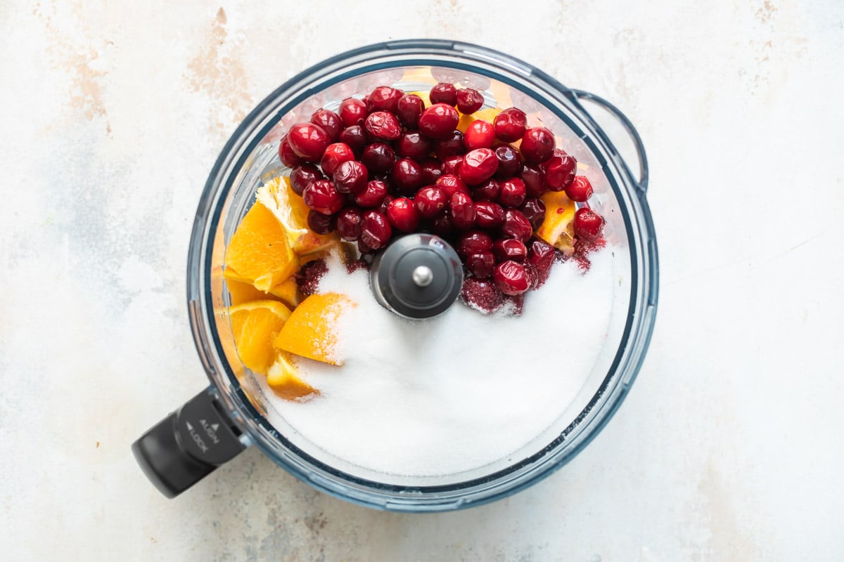 Ingredients for cranberry relish in a food processor.