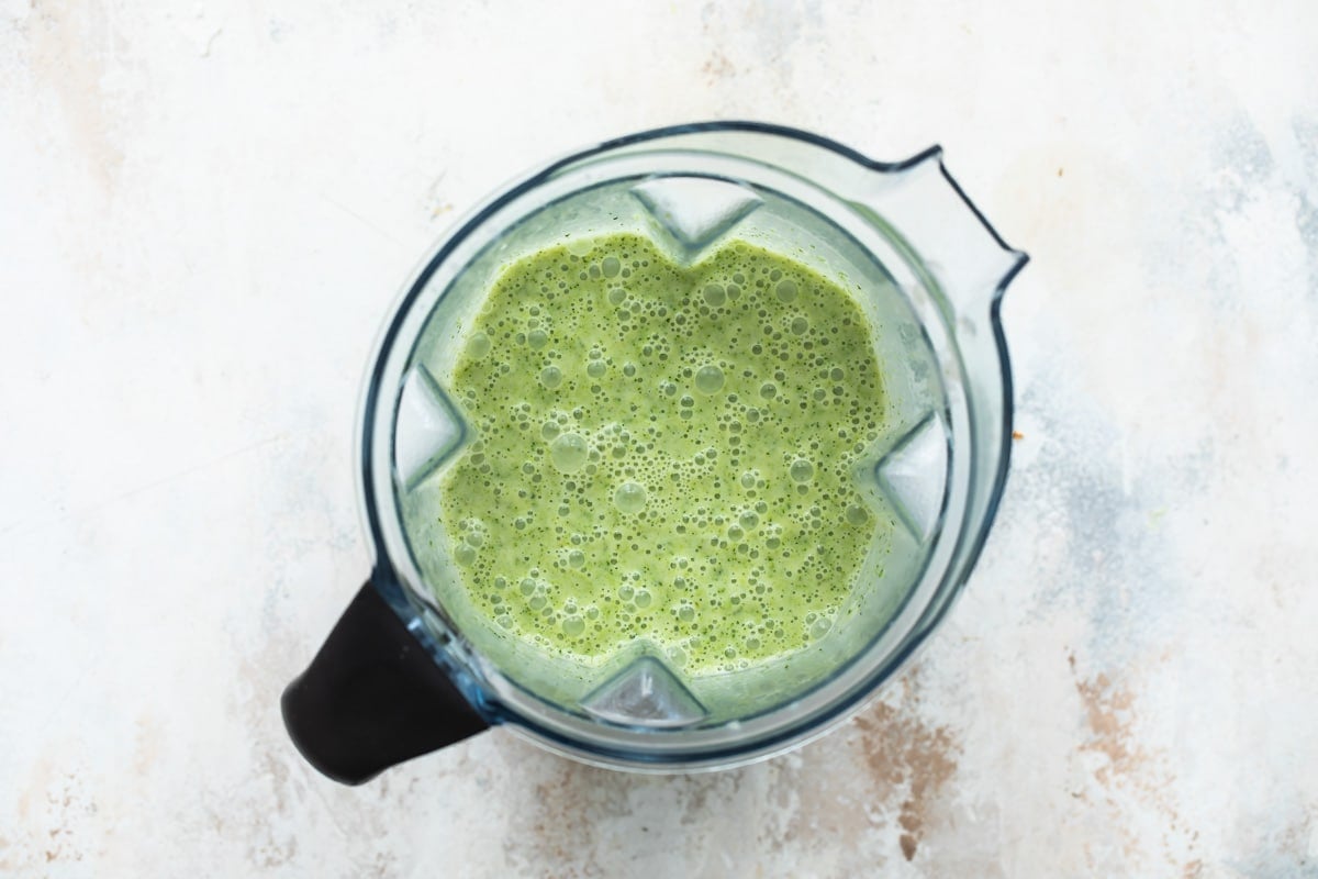 Green liquid in a blender pitcher.