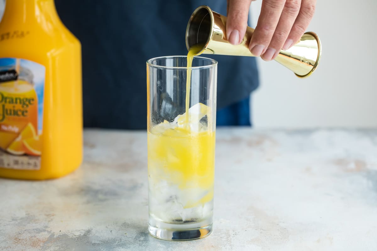Building a fuzzy navel cocktail.