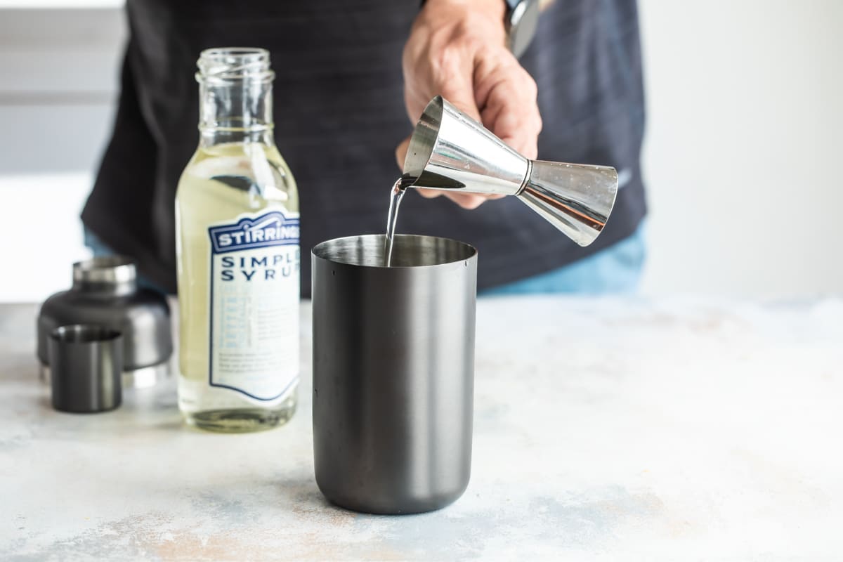 Mixing a gin fizz in a cocktail glass.