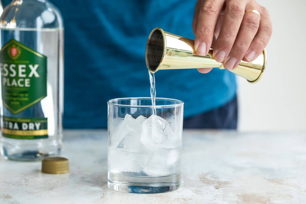 Mixing a gin and tonic in a glass.