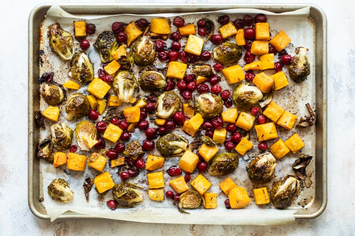 Harvest roasted vegetables on a parchment paper lined sheet pan.