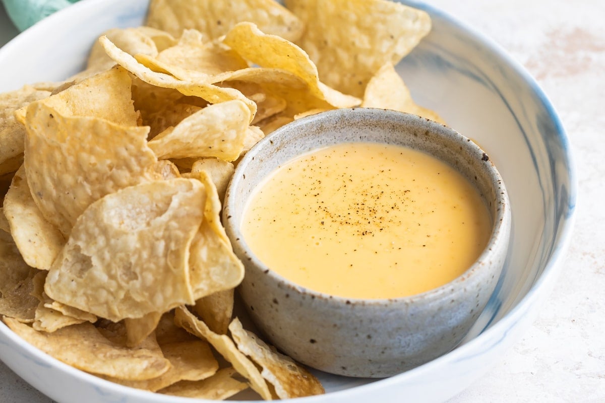 Tortilla chips next to homemade cheese sauce.