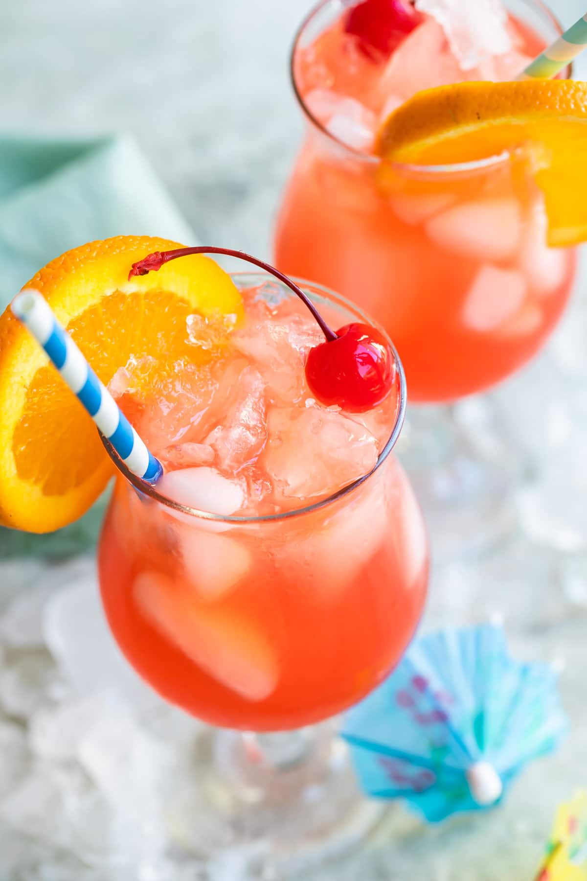 Two hurricane cocktails in hurricane glasses.