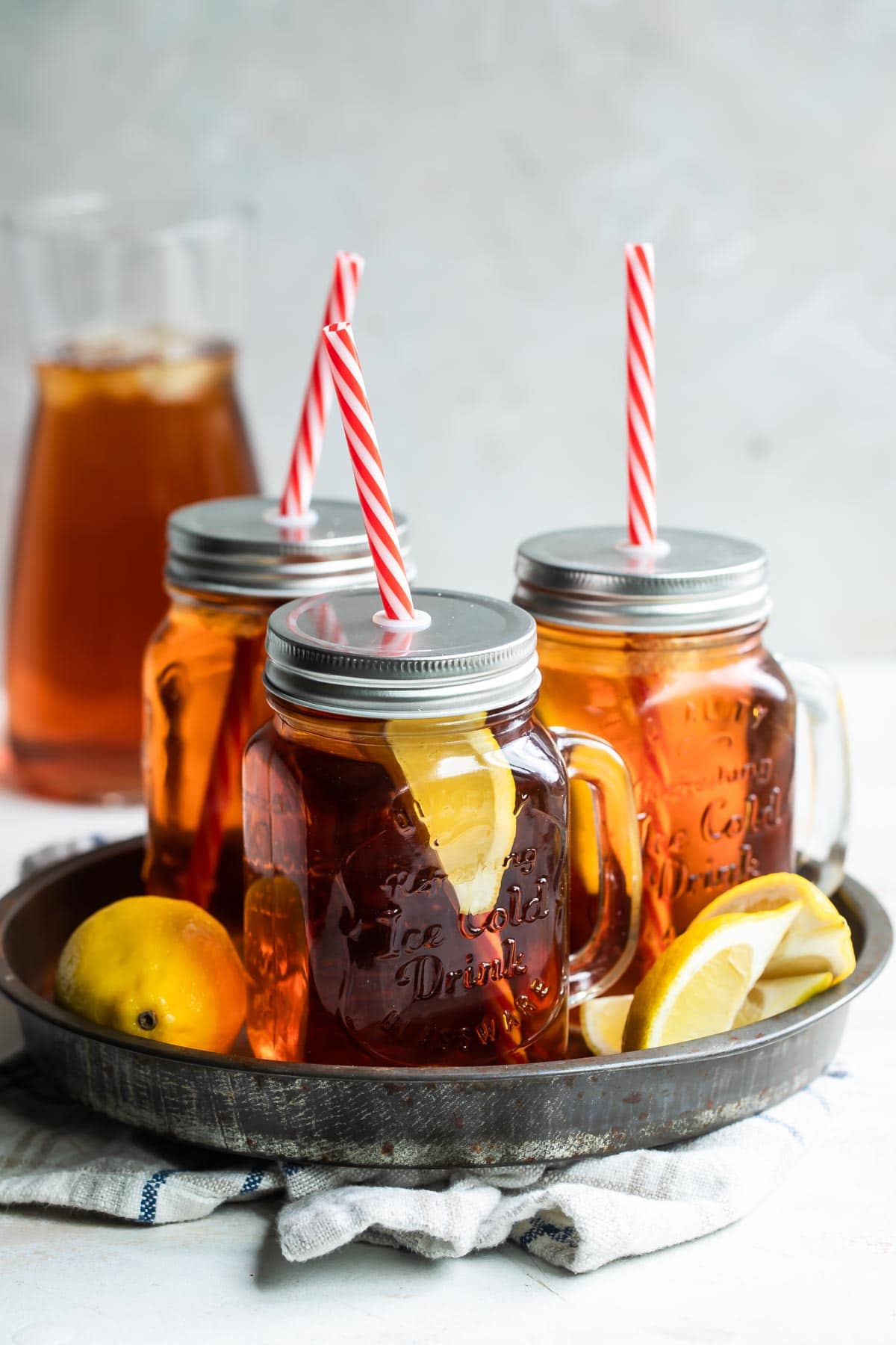 Glass mugs of iced tea on a tray.