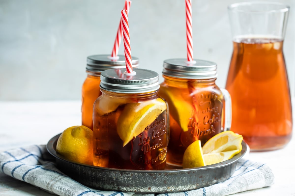 Glass mugs of iced tea on a tray.