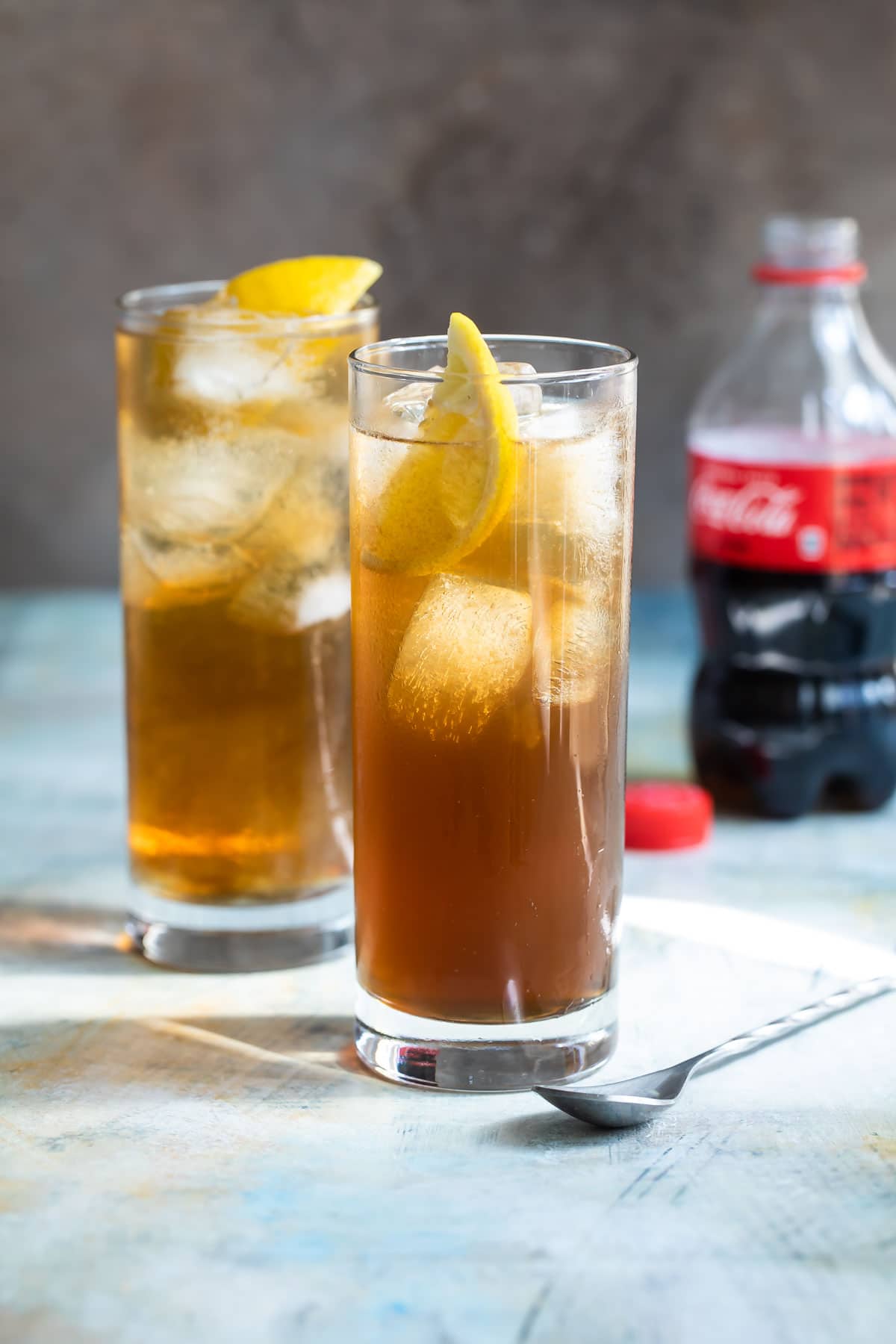 Two highball glasses of long island iced tea.