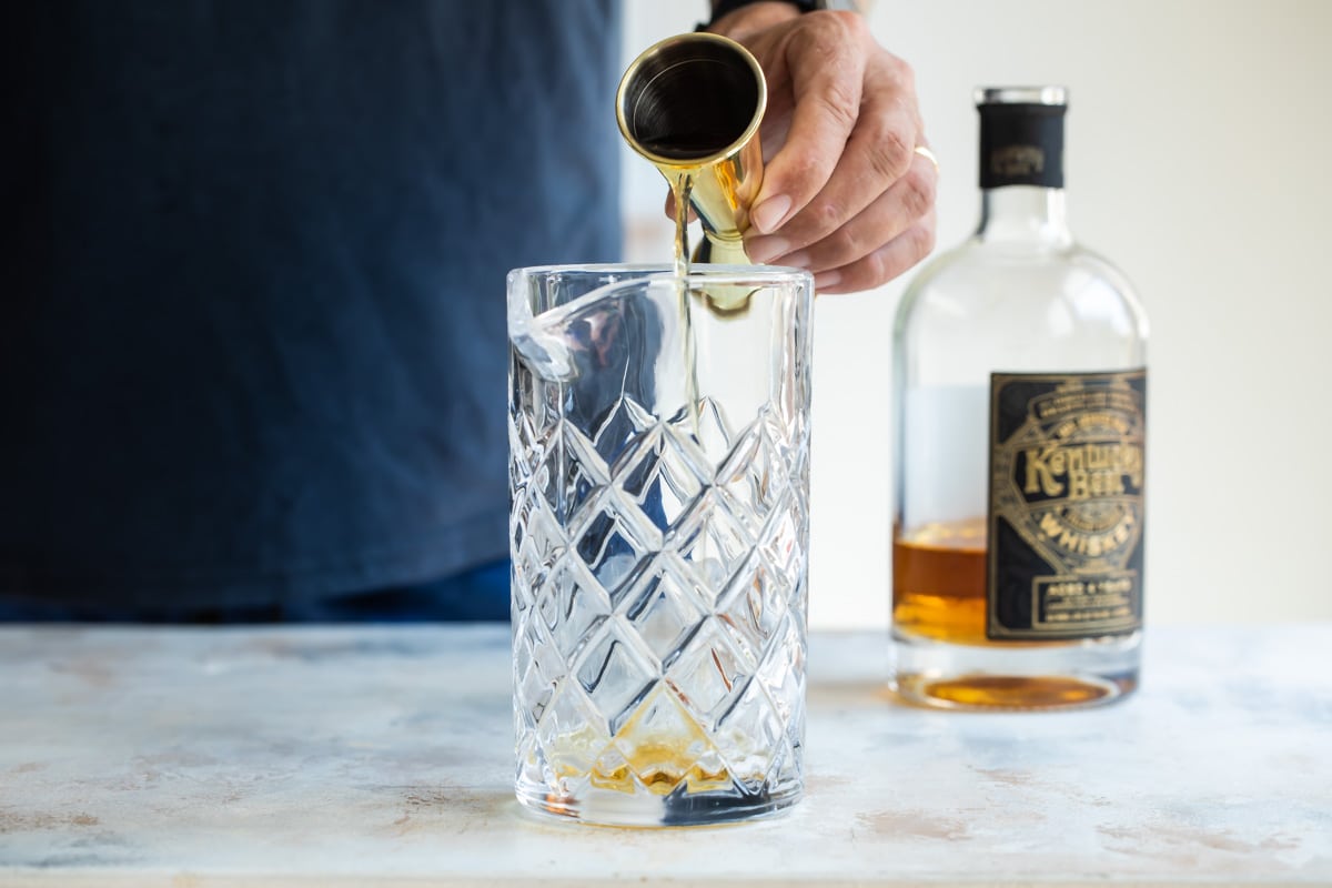 Making a manhattan cocktail in a mixing glass.