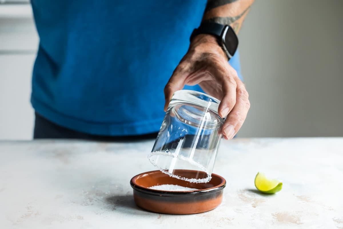 Rimming a glass with coarse salt.