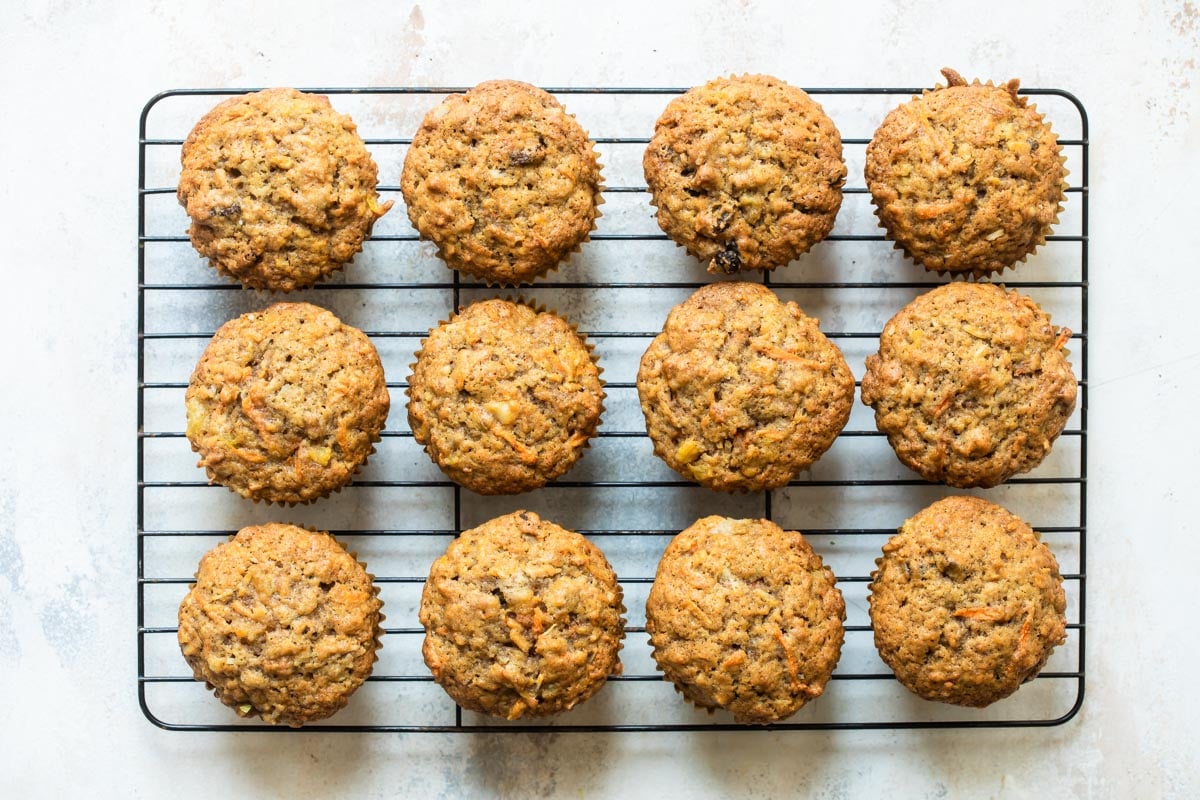 Twelve morning glory muffins on a cooling rack.