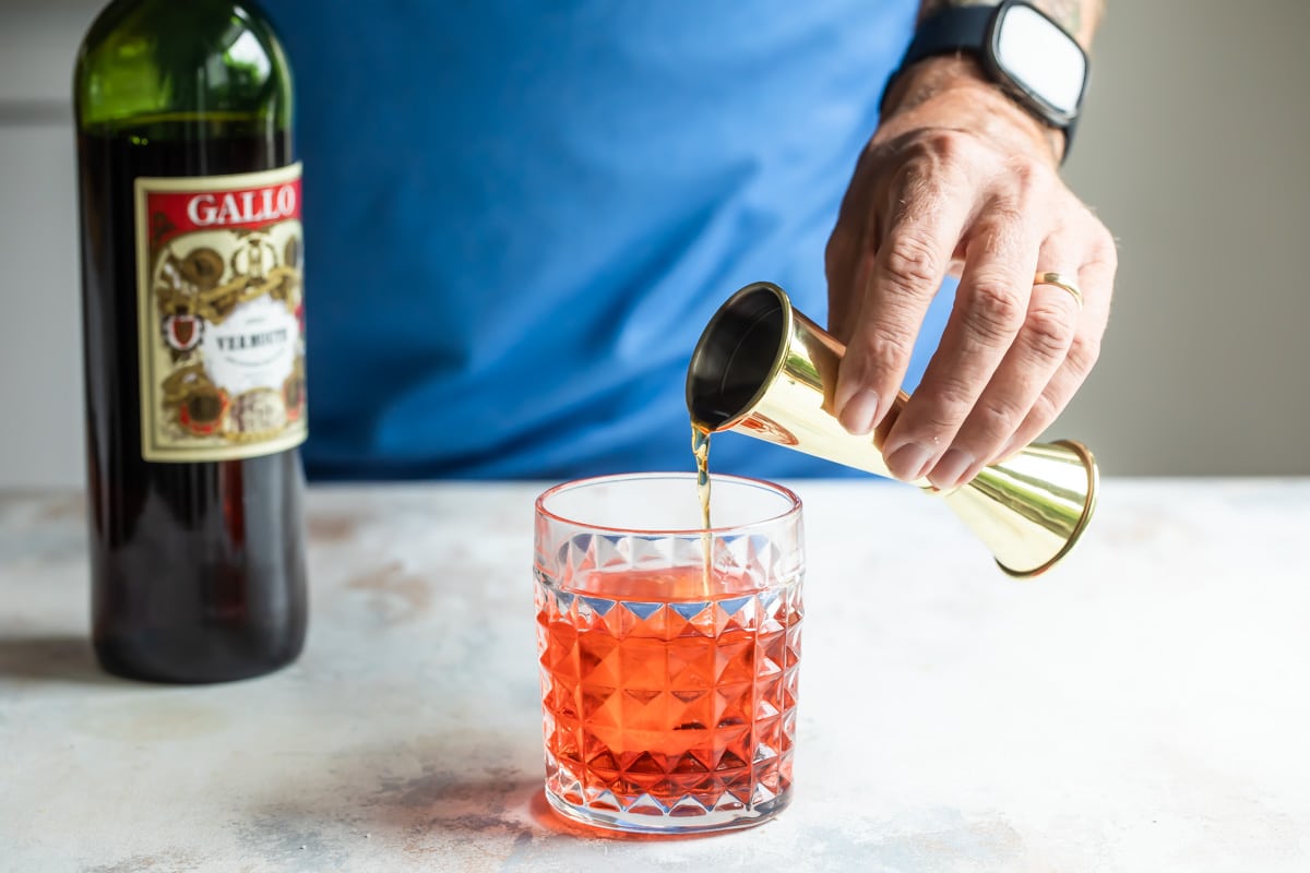 Making a negroni cocktail in a rocks glass.