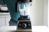 A blender with white liquid being mixed in it.