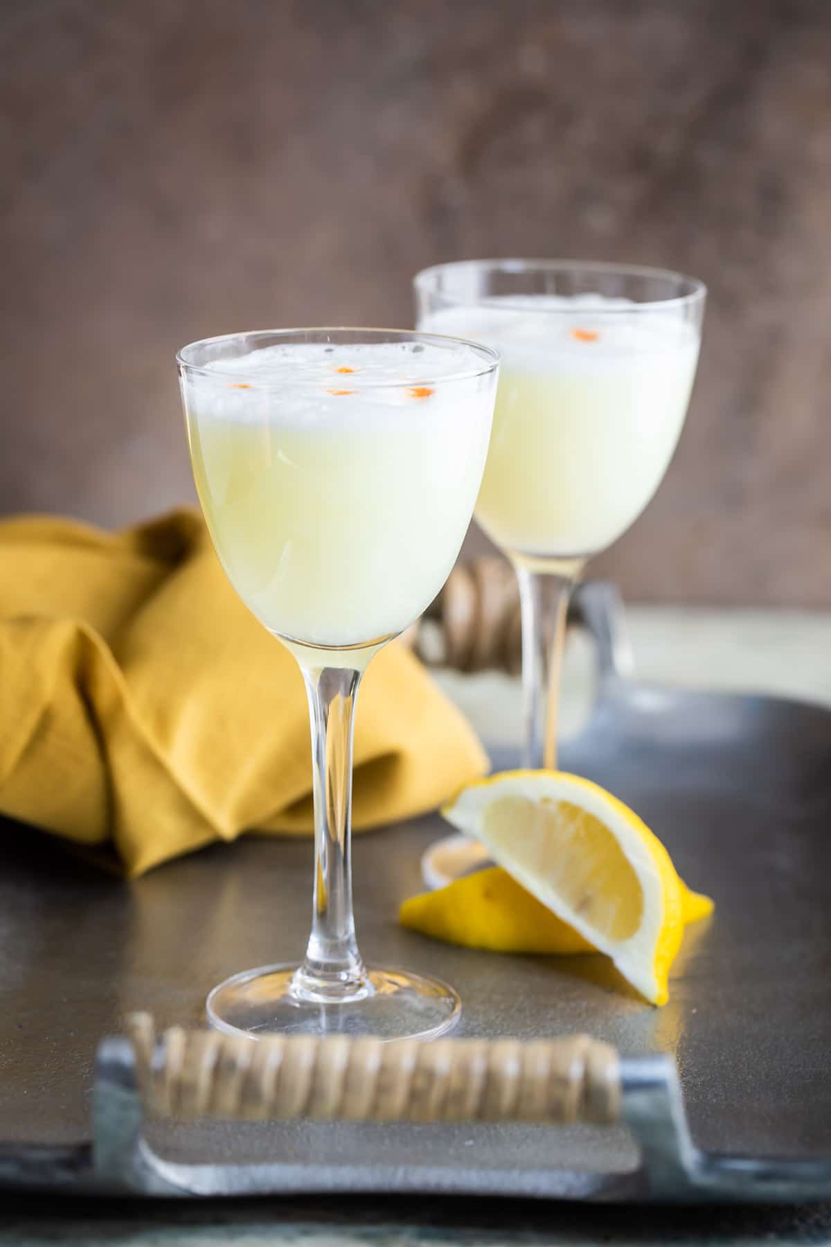 Two Pisco Sours in Nick and Nora glasses.