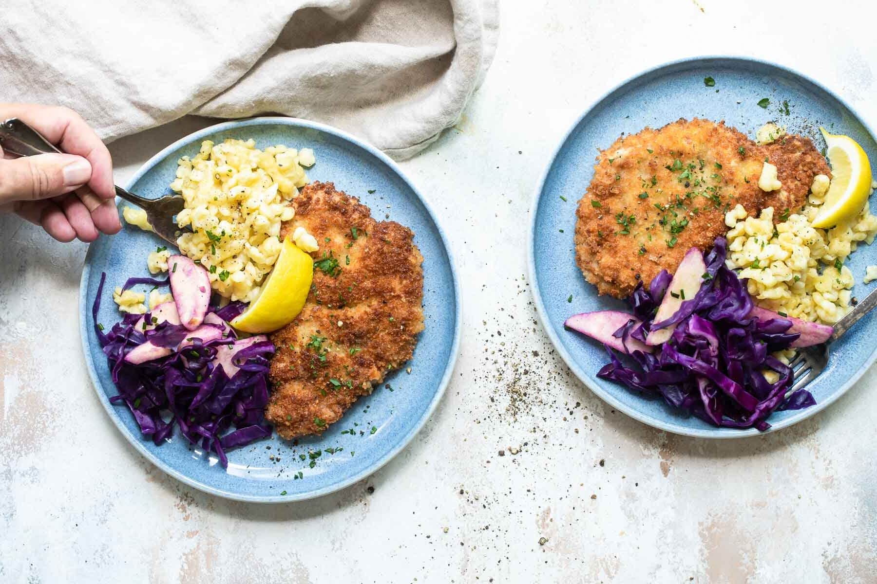 Plates of pork schnitzel, braised red cabbage, and spaetzle.