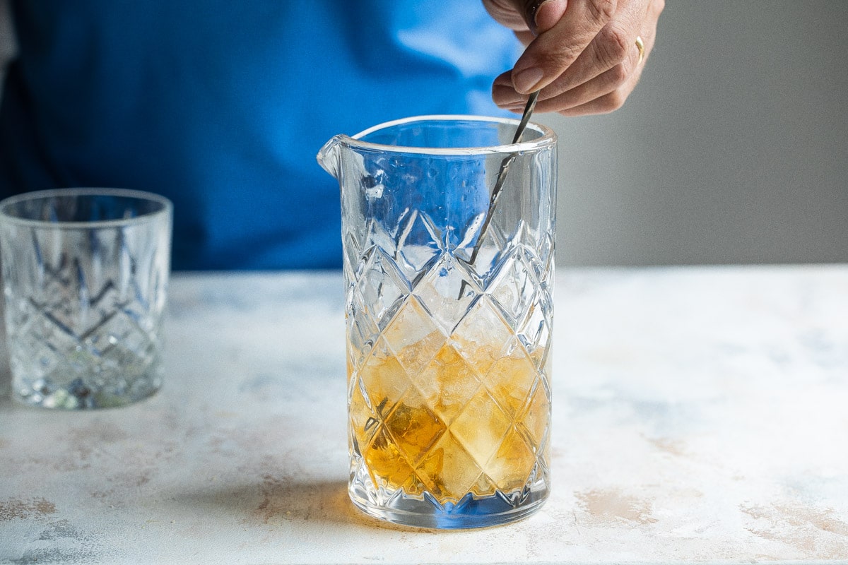 Mixing a Sazerac in a mixing glass.