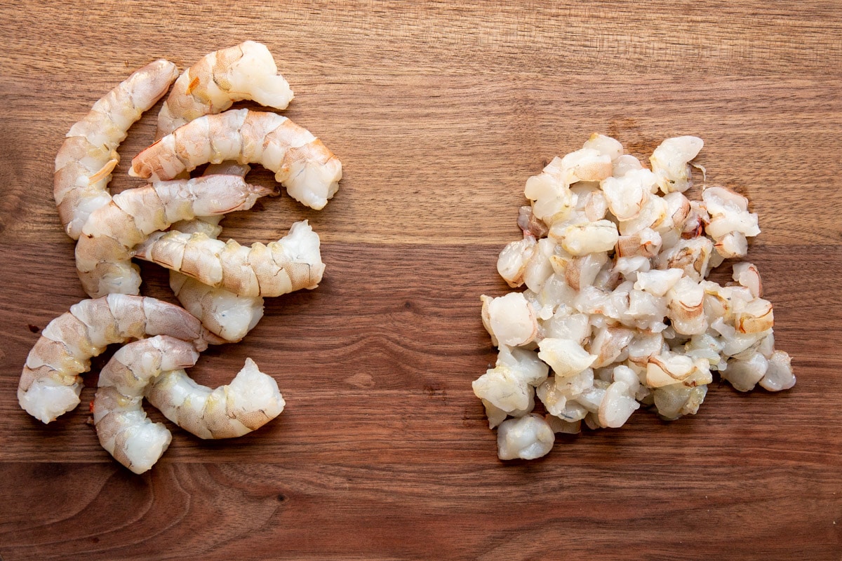 Raw shrimp on a cutting board.