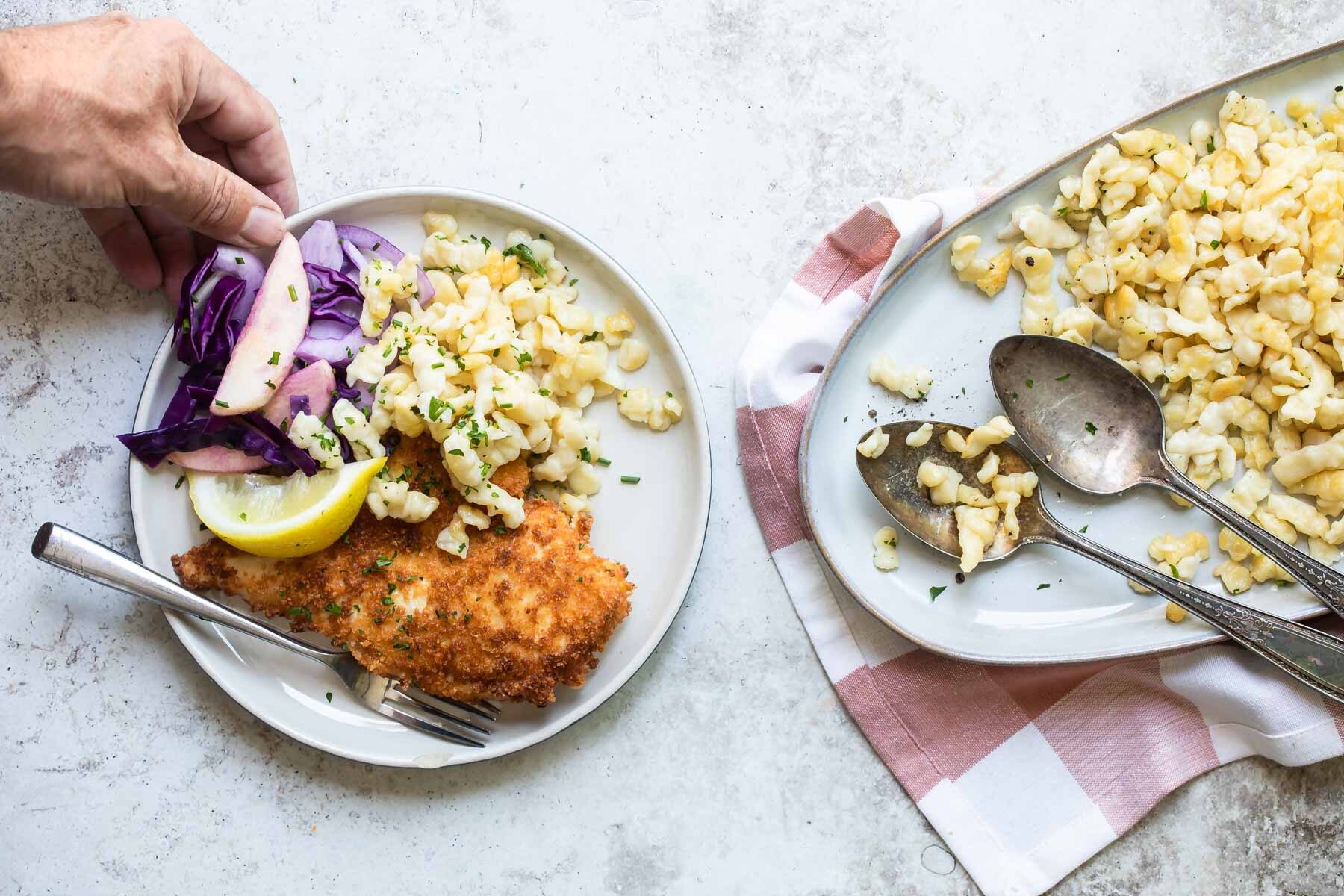 Plates with spaetzle, schnitzel, and red cabbage.