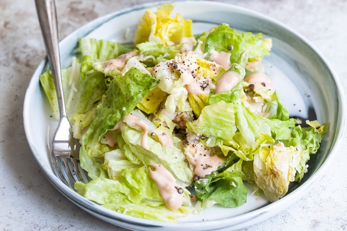 A salad with thousand island dressing on it.