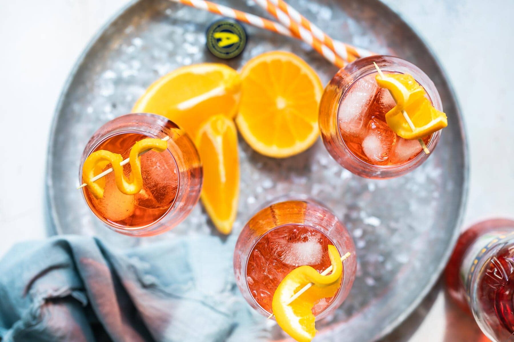 3 Aperol Spritz cocktails ona. metal tray.
