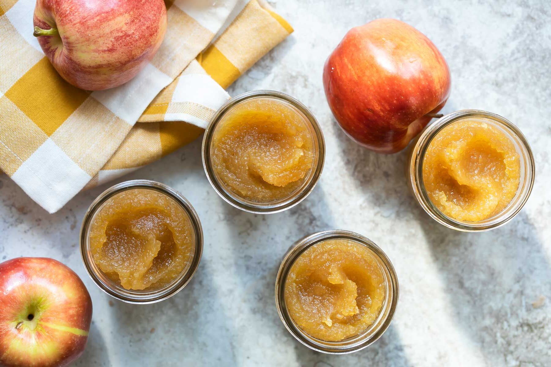 Apple butter in four mason jars.
