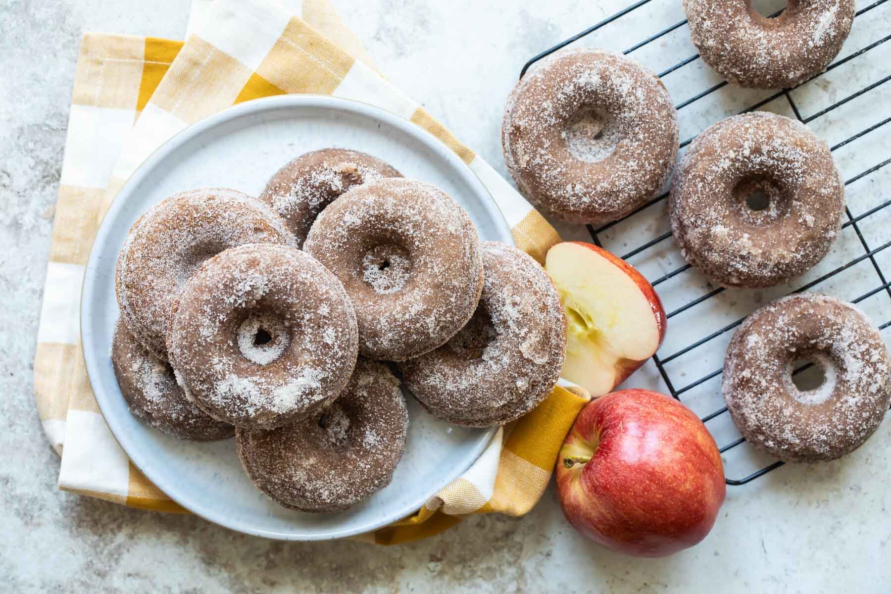 Seven apple cider donuts on a gray round plate.