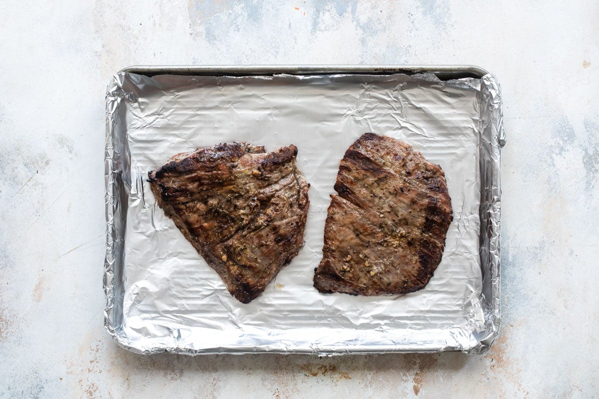 Cooked pieces of beef on a baking sheet.