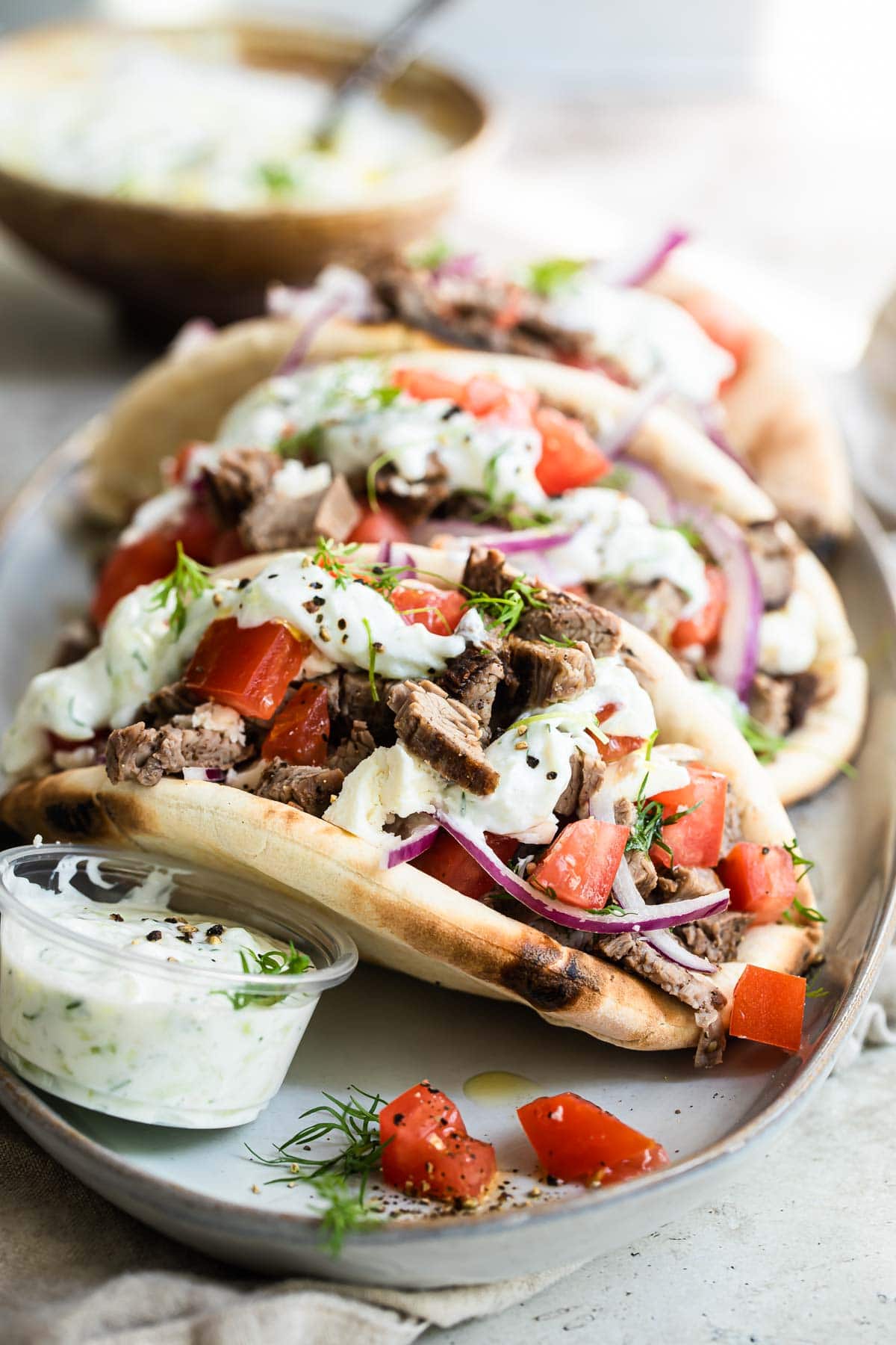 Three beef gyros on a plate.