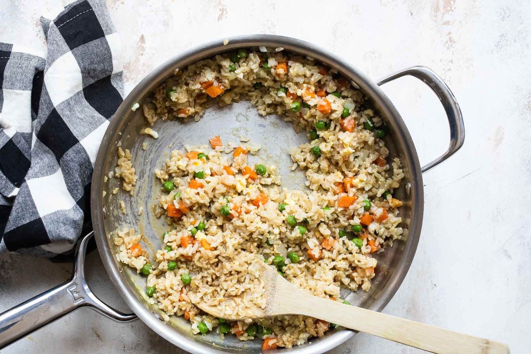 Brown fried rice in a silver skillet.