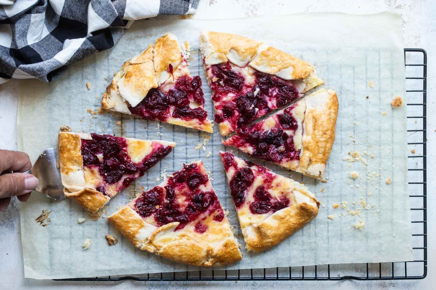 Cranberry cheesecake galette on a piece of parchment paper over a cooling rack.