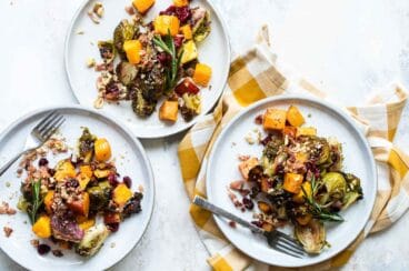 Three servings of harvest roasted vegetables on separate white plates.