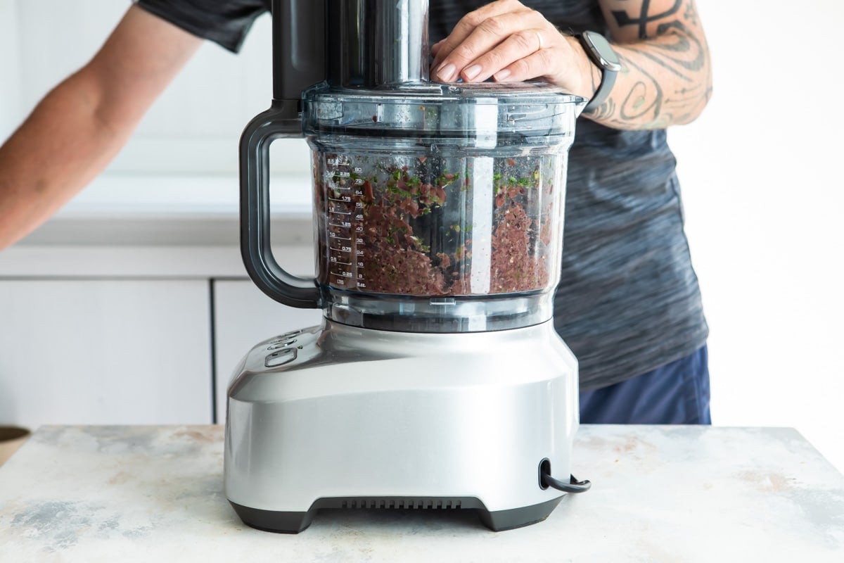 Olive tapenade being processed in a food processor.