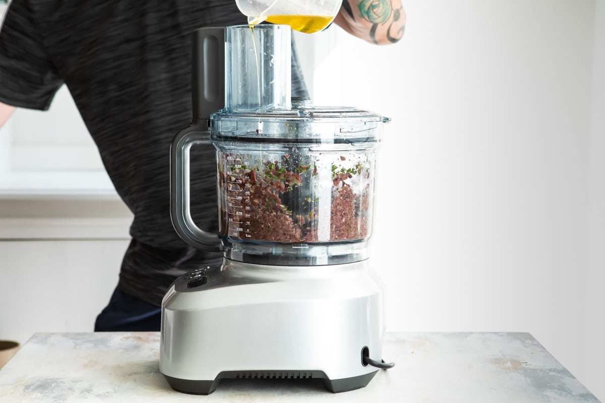 Olive tapenade being processed in a food processor.
