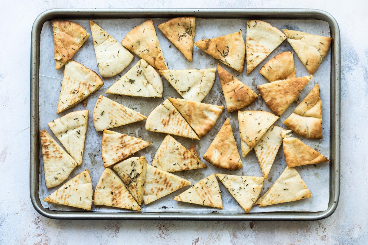 Homemade pita chips on a baking sheet.