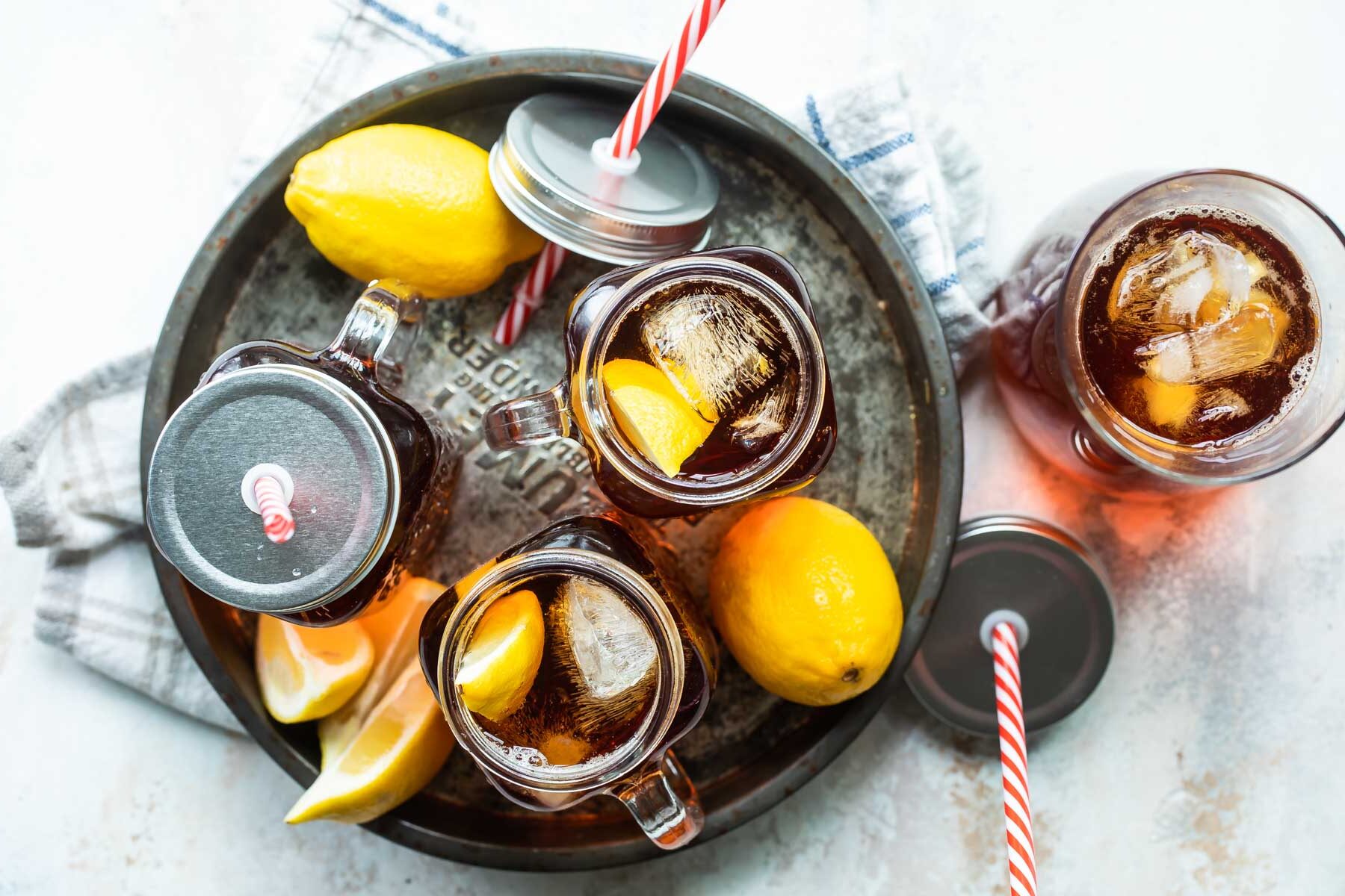 Glass mugs of iced tea on a tray.