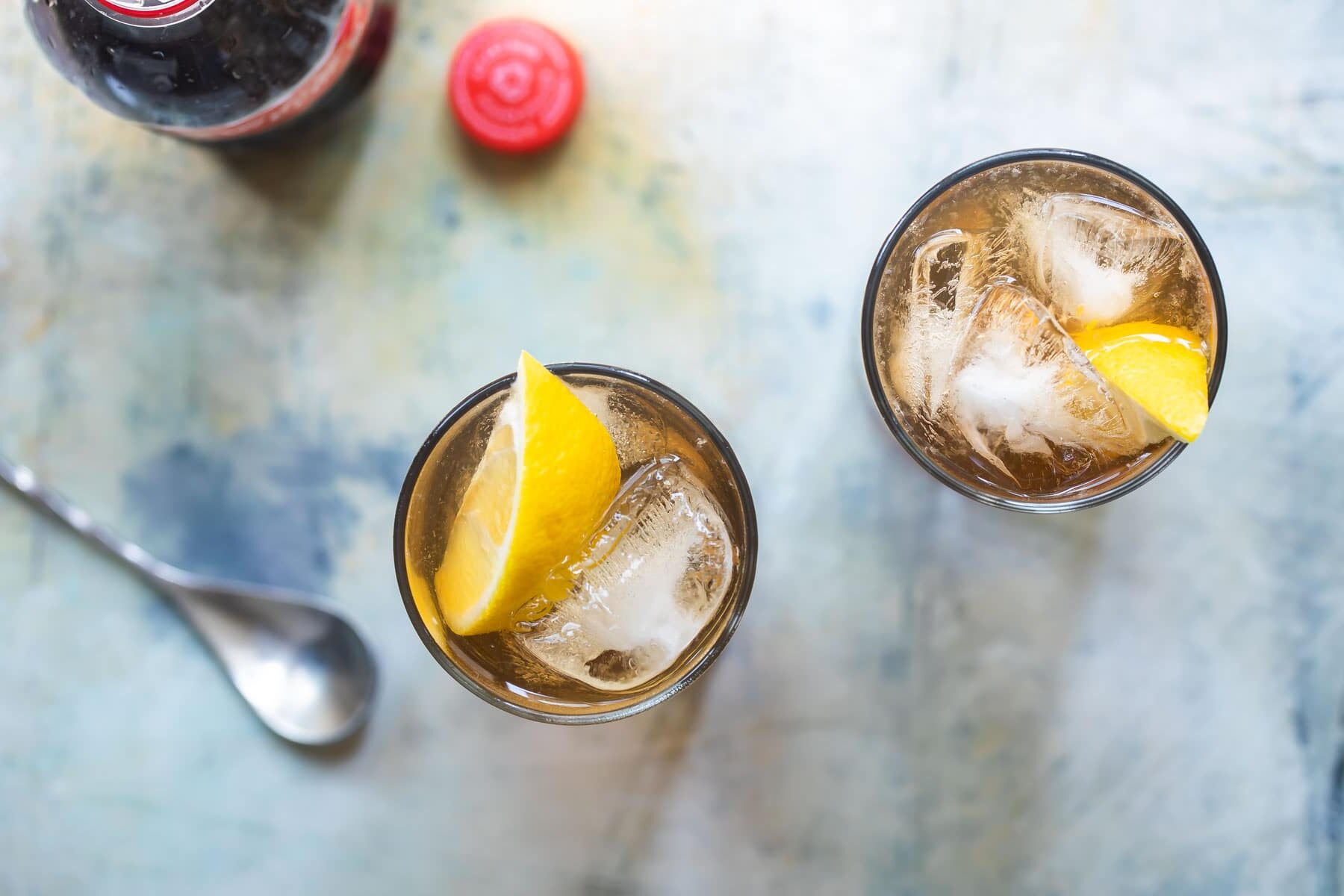 Two highball glasses of long island iced tea.