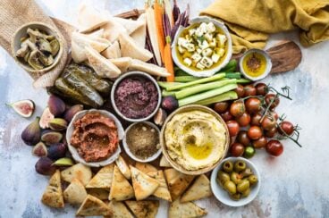 Dukkah, eggplant dip, hummus, artichokes, and olives in bowls