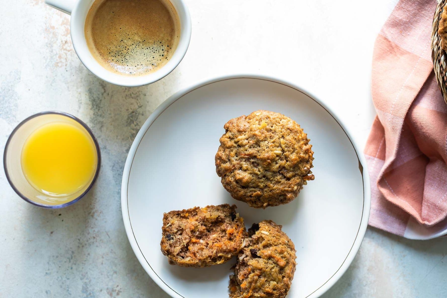 Two morning glory muffins on a white plate.