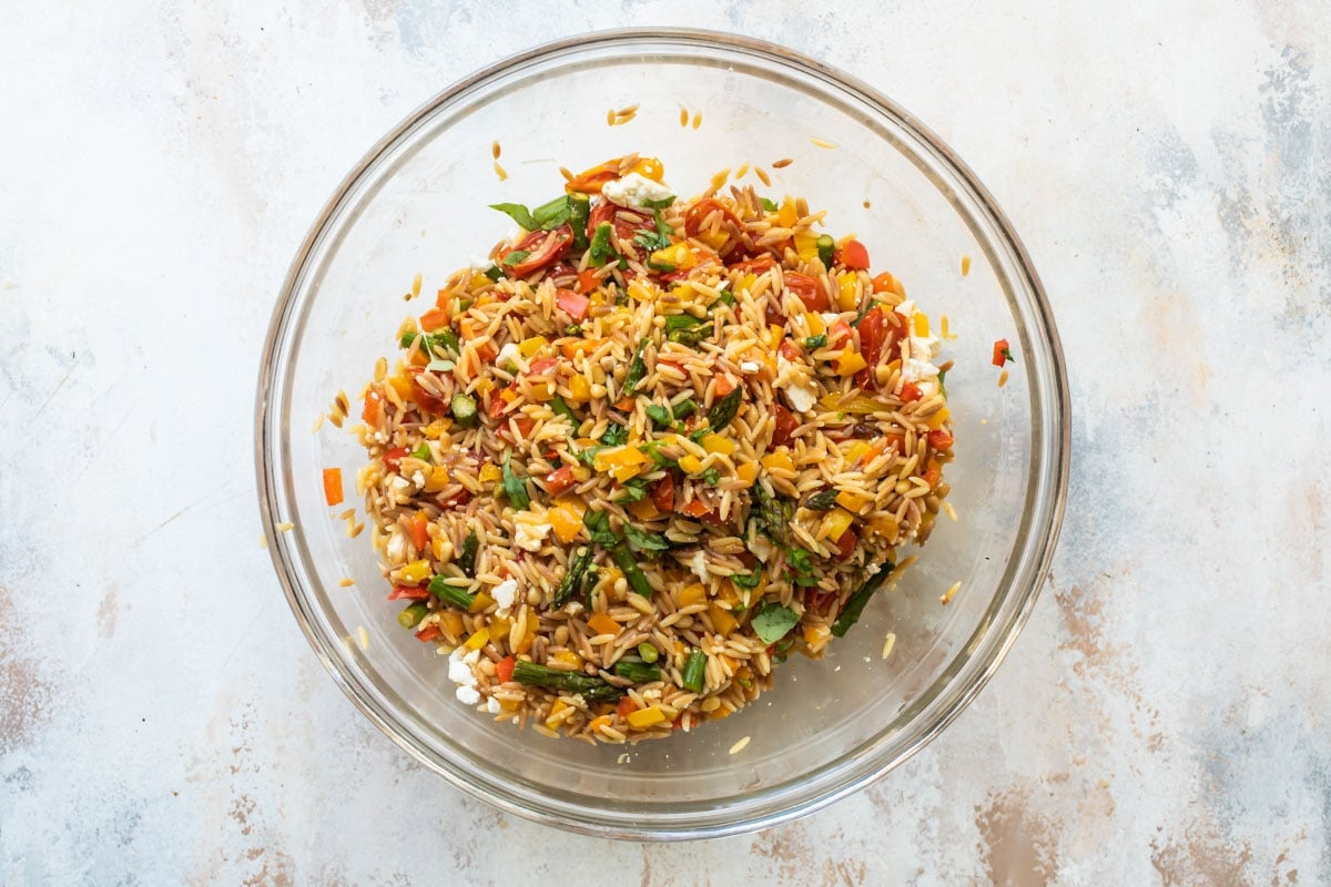 Orzo pasta salad in a clear bowl.
