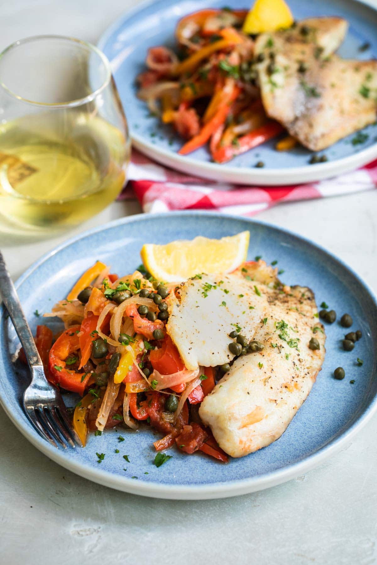 Two plates of pan fried tilapia.