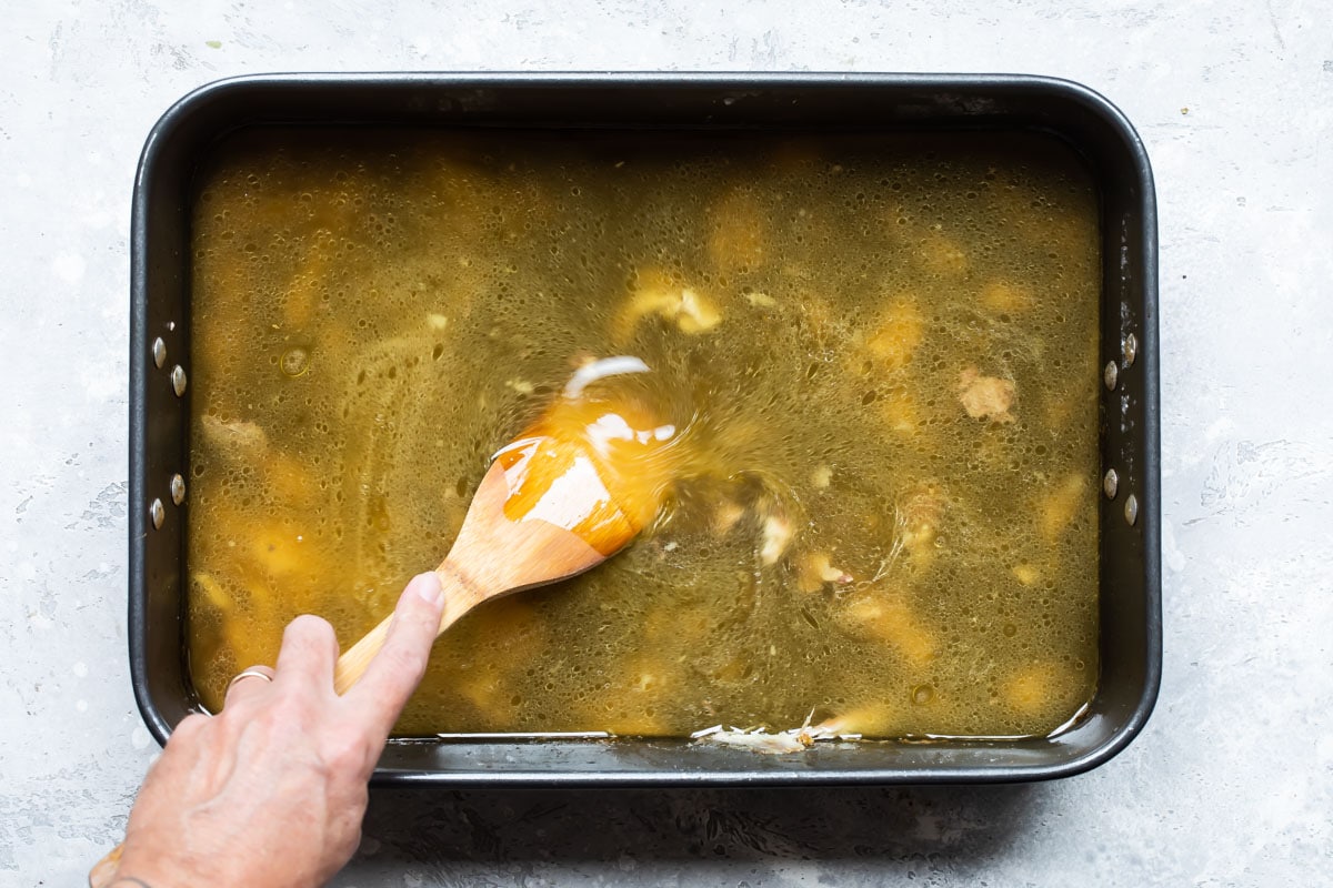 Whisking turkey drippings in a pan to make gravy.