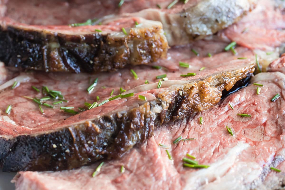 Prime rib slices in a white serving bowl.