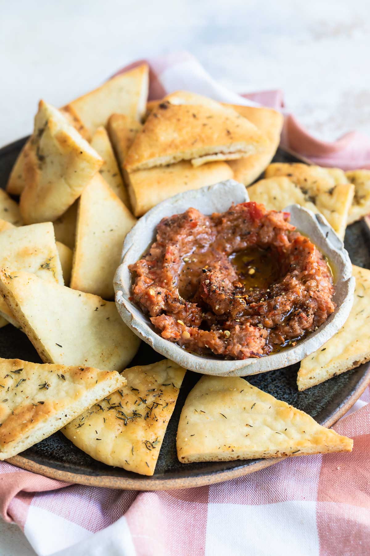 Roasted eggplant dip on a plate with triangles of bread.