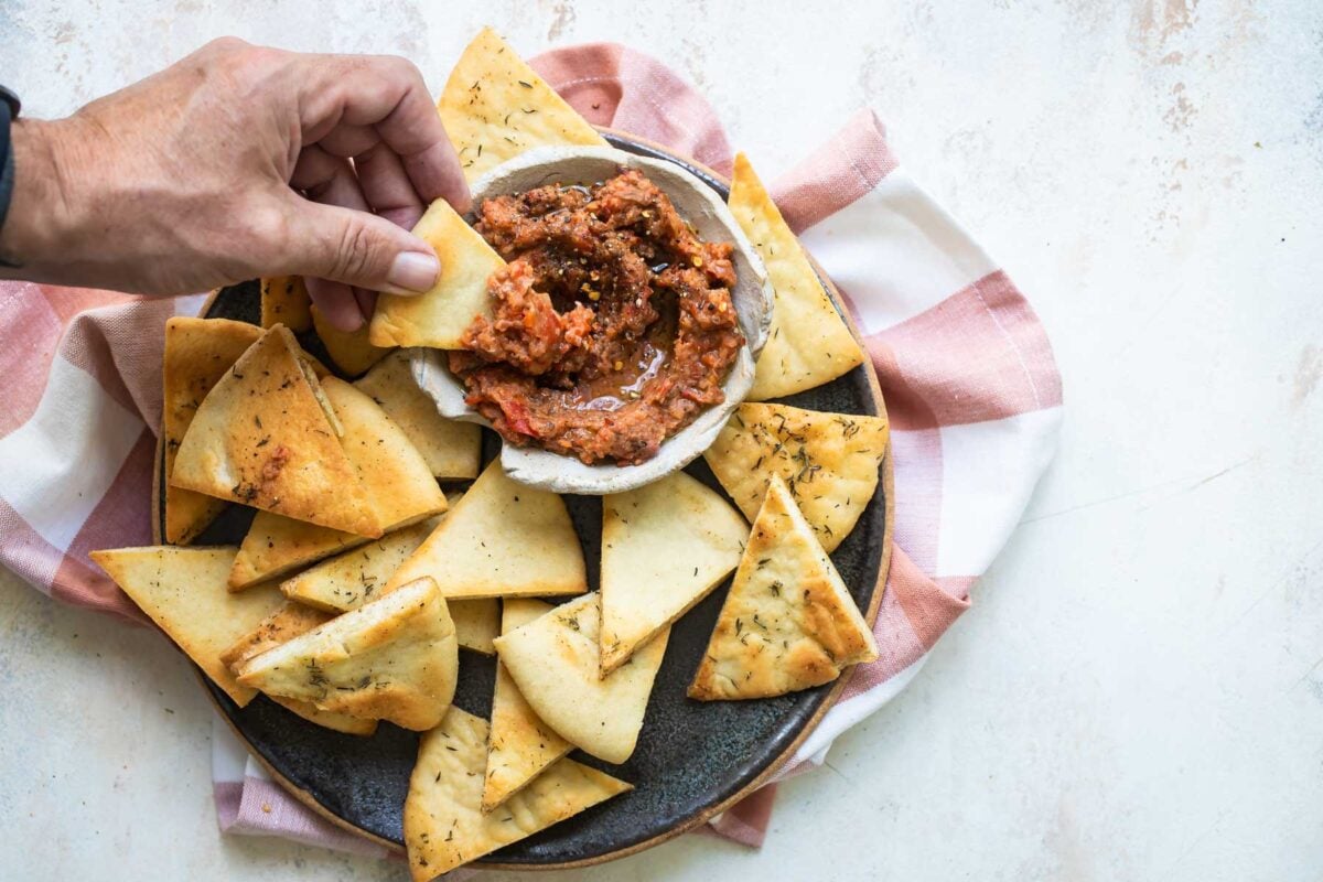 Roasted eggplant dip on a plate with triangles of bread.