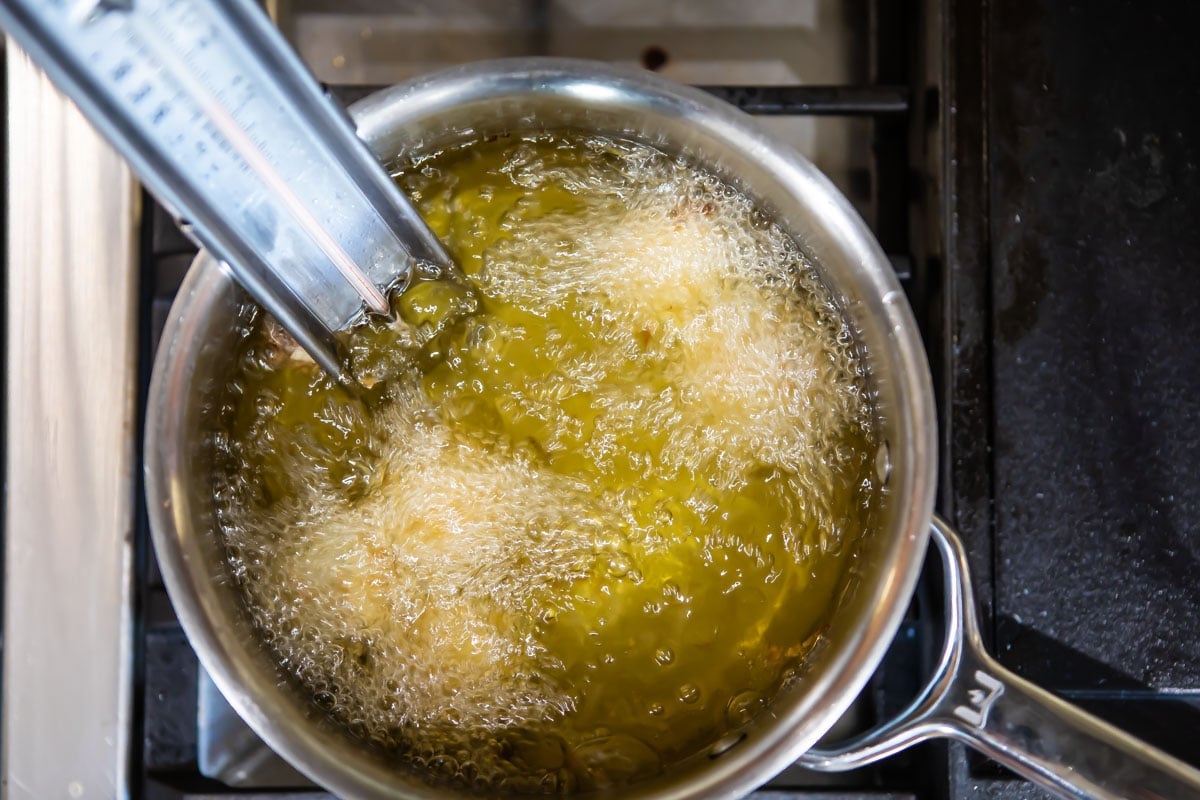 Jalapeño poppers frying in oil.