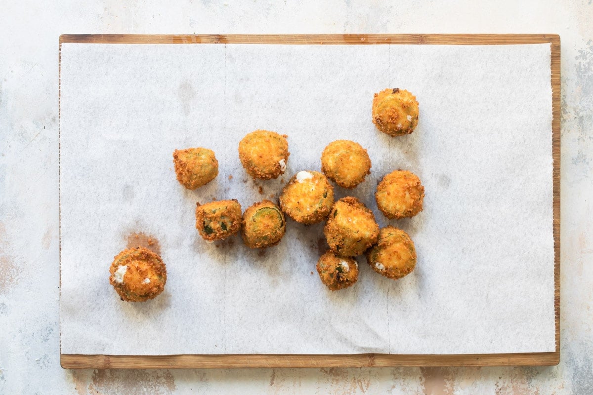 Jalapeño poppers draining on paper towels.