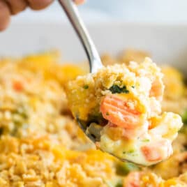 A pan of vegetable casserole with Velveeta and cracker crumbs.