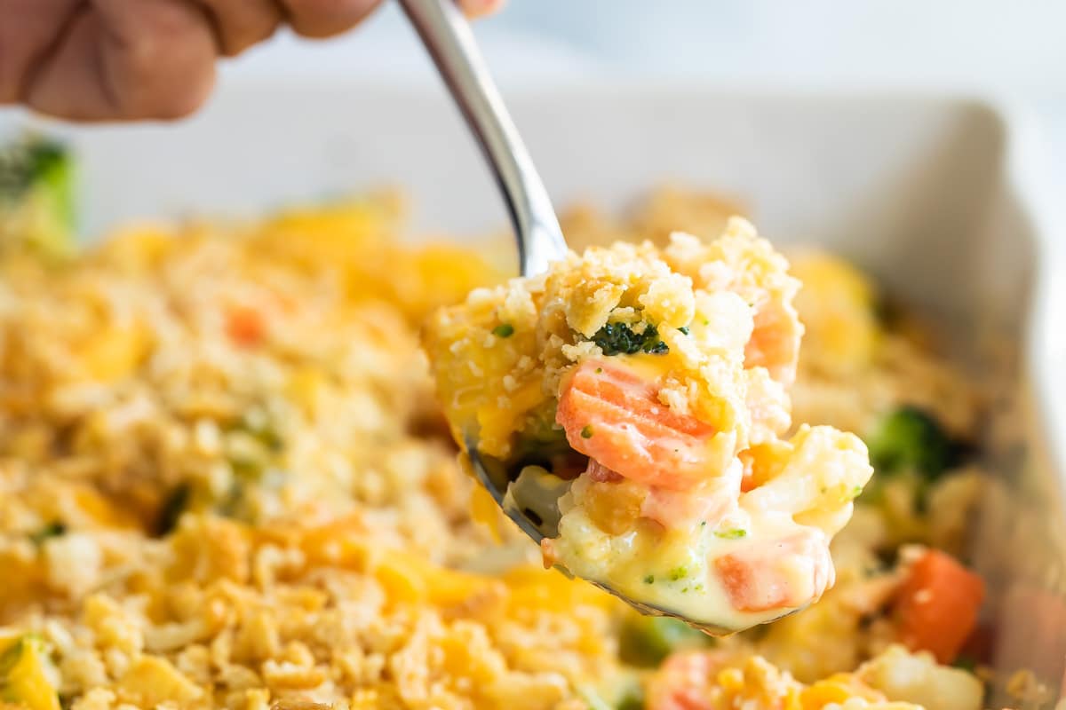 A pan of vegetable casserole with Velveeta and cracker crumbs.