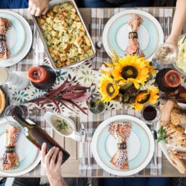 A table set for Thanksgiving with turkey, mashed potatoes, stuffing, and pumpkin pie.