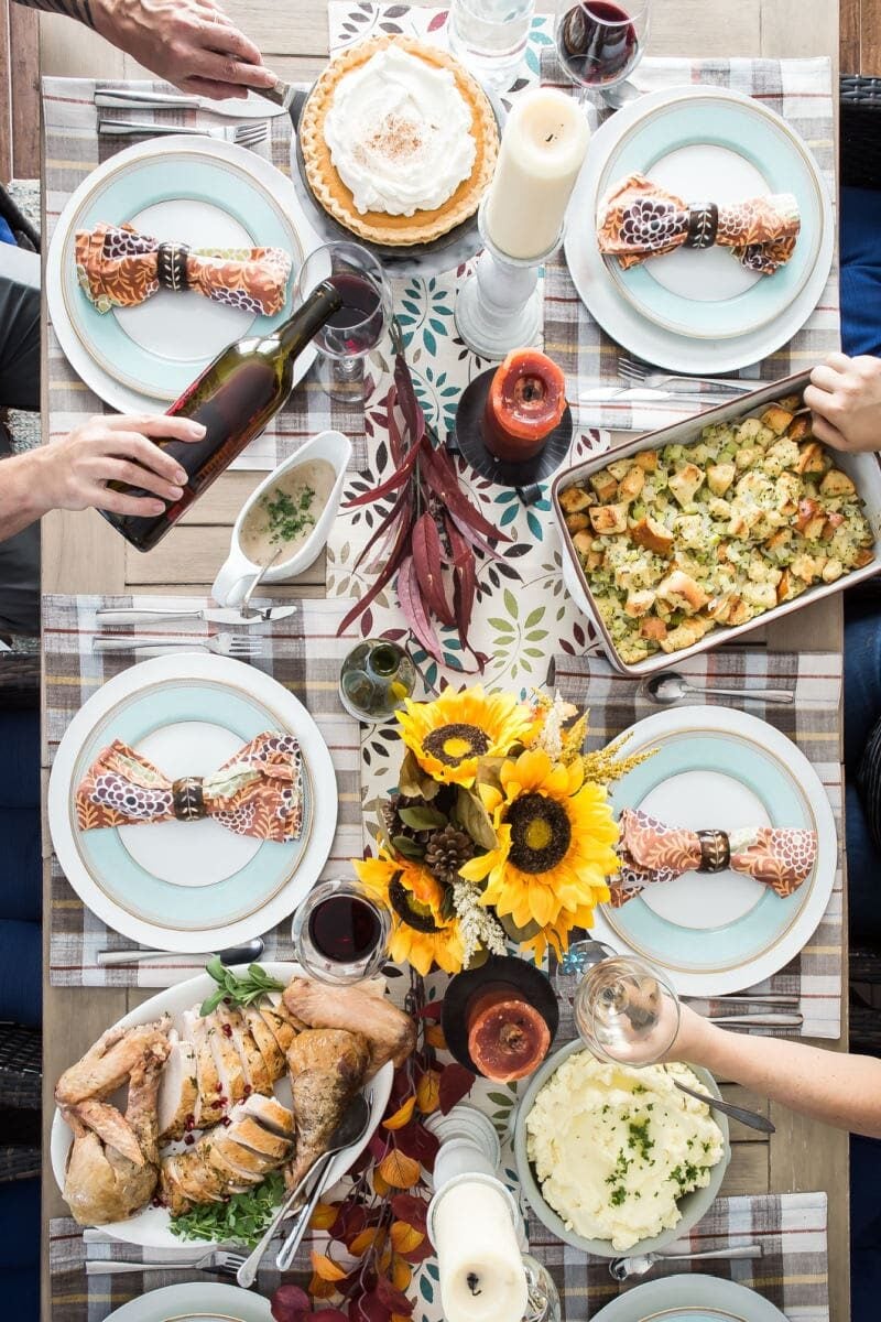 A table set for Thanksgiving with turkey, mashed potatoes, stuffing, and pumpkin pie.